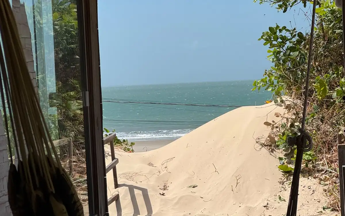 Rede na varanda do chalé Pé na Areia, de frente para a duna e o mar