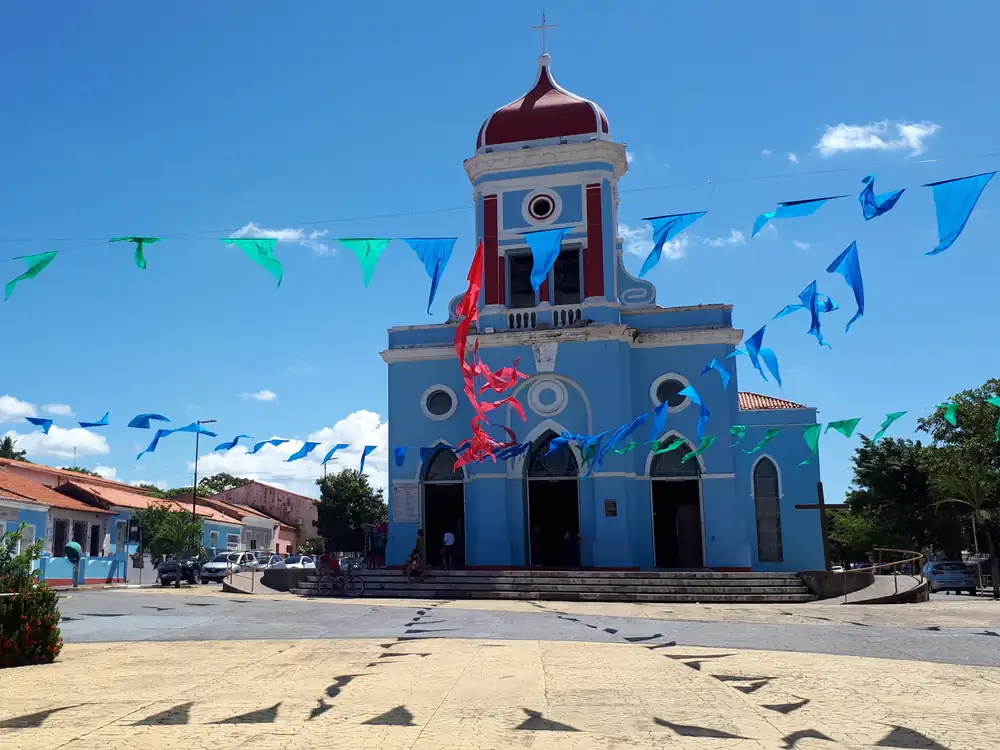 A igreja matriz de São José de Ribamar, azul, com bandeirinhas na praça em frente