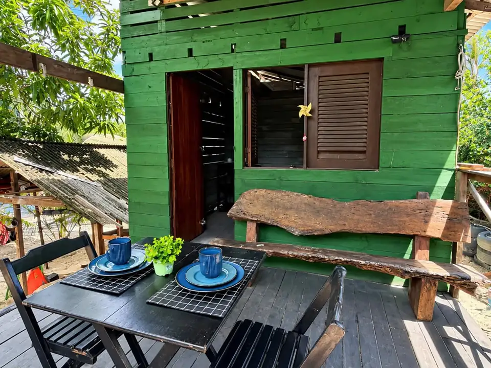 Varanda verde do Lua de Sal, com mesa e banco de madeira
